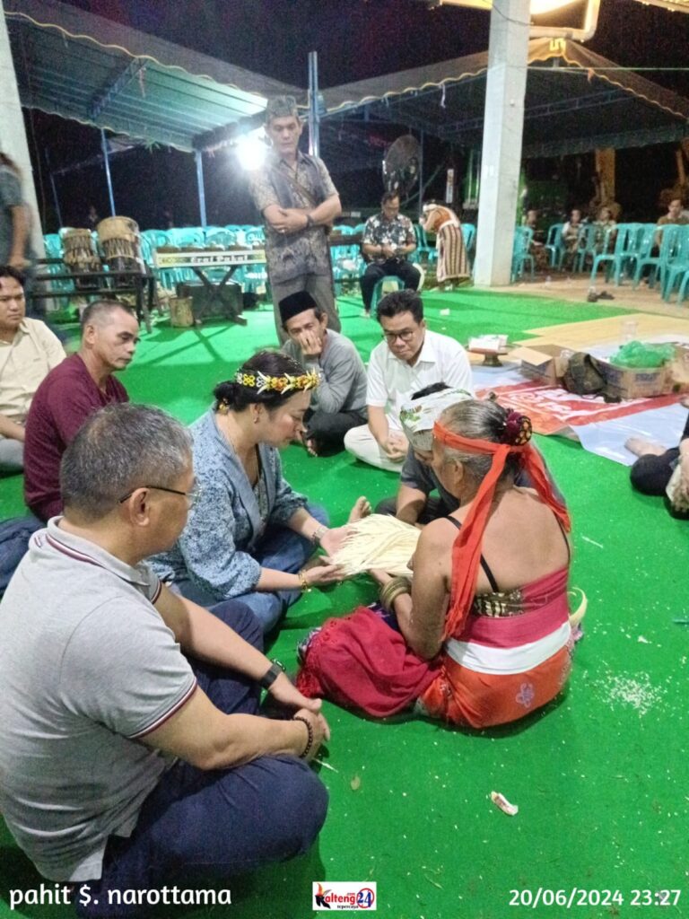 Wamen LHK Alue Dohong dan Pancani Gandrung sedang memerhatikan bagian prosesi ritual Tolak Bala yang dilakukan oleh salah seorang Wadian (pelaksana ritual).